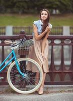 giovane donna bellissima, elegantemente vestita con la bicicletta foto