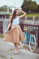 giovane donna bellissima, elegantemente vestita con la bicicletta foto