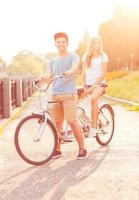 giovane uomo e donna equitazione un' bicicletta nel il parco all'aperto foto