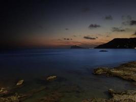 spiaggia tranquilla nel tardo pomeriggio con luce artificiale e naturale mista foto