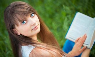 bellissimo ragazza con libro nel il parco su verde erba foto