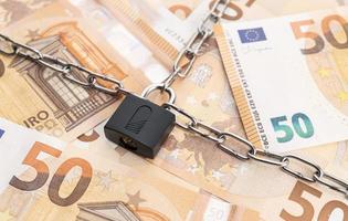 serratura sicurezza e catena su Euro banconote sfondo. monetario crisi, finanziario i problemi, sanzioni, predefinito concetto foto