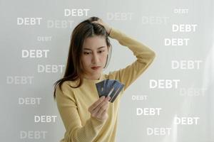 stressato e mal di testa asiatico donna con grande fatture o fatture no i soldi per pagare per spese e credito carta debito. carenza, finanziario i problemi, mutuo, prestito, fallimento, fallito, povero, vuoto portafoglio foto