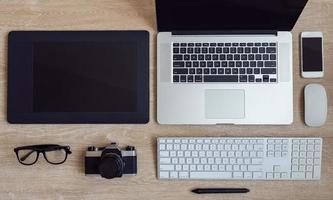 attività commerciale posto di lavoro con il computer portatile e gadget su di legno sfondo foto