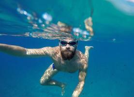 uomo fare subacqueo autoscatto tiro con autoscatto bastone nel blu mare foto