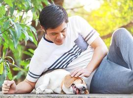 uomo asiatico con il suo cane in vacanza al parco foto