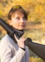 giovane bellissimo ragazza con un' fucile da caccia foto