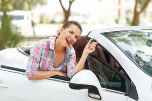 donna in piedi vicino convertibile con chiavi nel mano - concetto di acquisto un' Usato auto o un' noleggio auto foto