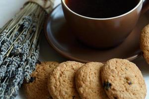 lavanda, biscotti e tazza di tè su bianca di legno sfondo foto