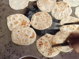 cucinando roti chapati su un' grande cucinando padella foto