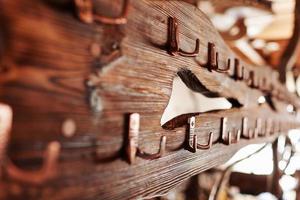 un' rustico di legno tavola con metallo ganci. Abiti appendiabiti oro acciaio ganci su Marrone di legno sfondo foto