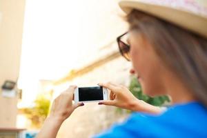 ragazza nel cappello fabbricazione fotografie di un' Chiesa di il smartphone