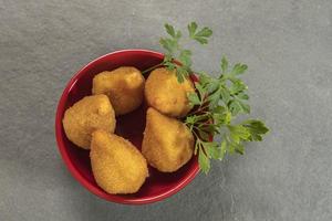 tradizionale fritte coxinha nel piatto su ardesia sfondo, popolare brasiliano merenda foto