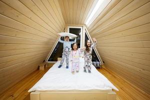 bambini nel morbido caldo pigiama giocando a di legno cabina casa. concetto di infanzia, tempo libero attività, felicità. fratello e sorelle avendo divertimento e giocando insieme. foto