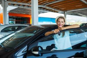 contento donna in piedi vicino un' auto con chiavi nel mano - concetto di acquisto un' Usato auto foto