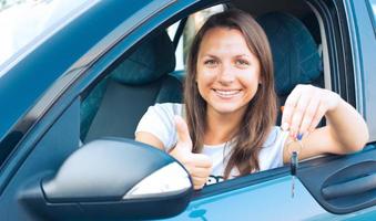 signora seduta nel un' auto e mostrando chiave foto