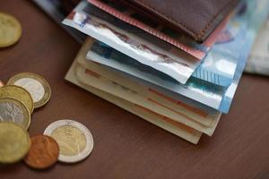 Marrone portafoglio con Euro i soldi dentro e monete, credito carte vicino esso foto