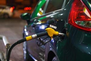 auto rifornimento carburante su un' benzina stazione nel inverno a notte foto