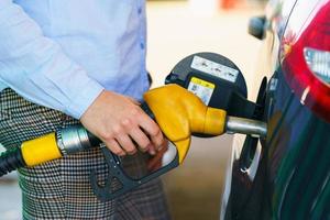 donna riempimenti benzina in il auto a un' gas stazione foto