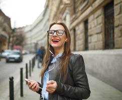 donna d'affari a piedi giù il strada mentre parlando su inteligente Telefono foto