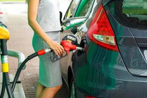 donna riempimenti benzina in il auto a un' gas stazione foto