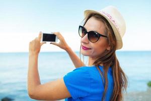 ragazza nel cappello fabbricazione fotografie di il Adriatico mare di il smartphone