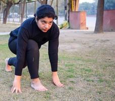 giovane indiano donna praticante yoga all'aperto nel un' parco. bellissimo ragazza pratica di base yoga posa. quiete e relax, femmina felicità. di base yoga pose all'aperto foto