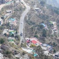 vista aerea dall'alto dei veicoli stradali che guidano su strade di montagna a nainital, india, uttarakhand, vista dal lato superiore della montagna per il movimento di veicoli stradali foto