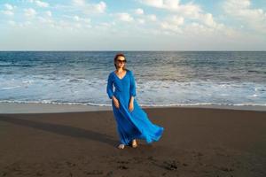 donna con lungo vestito su il spiaggia foto