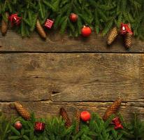 Natale confine con abete albero rami, coni e Natale decorazioni su rustico di legno tavole foto