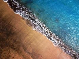 superiore Visualizza di un' abbandonato spiaggia. costa di il isola di tenerife. aereo fuco metraggio di mare onde raggiungendo costa. foto