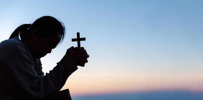 silhouette di donna in ginocchio giù preghiere per culto Dio a cielo sfondo. cristiani pregare per Gesù Cristo per calma. nel mattina persone avuto per un' silenzioso posto e pregato. bandiera con copia spazio. foto