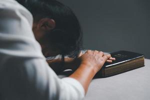 donna in ginocchio e preghiere nel moderno Casa a tramonto volta. femmina cattolico preghiera culto per Dio desiderio un' meglio vita nel casa a alba con credere fede. concetto di adoratori in ginocchio. foto