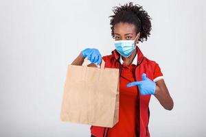 consegna donna Tenere carta Borsa nel medico gomma da cancellare guanti e maskshowing pollice su. copia spazio. veloce e gratuito consegna trasporto . in linea shopping e esprimere consegna . quarantena foto