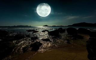 pieno Luna crescente al di sopra di oceano. notte paesaggio a spiaggia foto