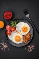 delizioso sostanzioso prima colazione consistente di Due fritte uova, in scatola Lenticchie e microgreens foto