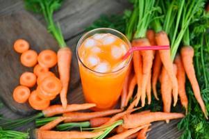 fresco e dolce carota fette per cucinando cibo frutta e verdure per Salute concetto, fresco carote succo su bicchiere con ghiaccio su estate, carota succo su di legno tavolo sfondo foto