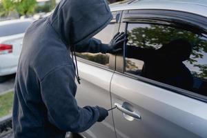 rapinatore rottura in un' auto a il parcheggio quantità. foto