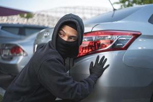 rapinatore nel nero maschera con macchina. rapina e crimine concetto. auto furto concetto. foto