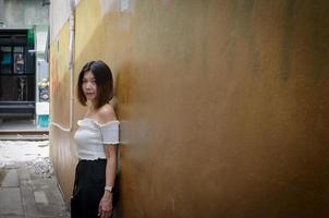 donna in posa contro un muro in un vicolo foto