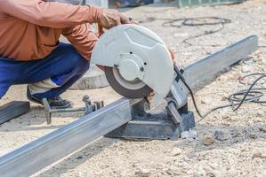 dell'uomo mano utilizzando ferro fresa nel il posto di lavoro, fissaggio ferro baldacchino telaio con scintilla. lavoratore taglio acciaio con elettrico ferro taglierina. acciaio fresa macinino taglio ferro tubo con luminosa scintille. foto