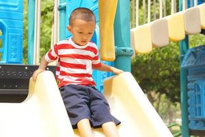 ragazzo giocando nel il terreno di gioco nel il parco foto