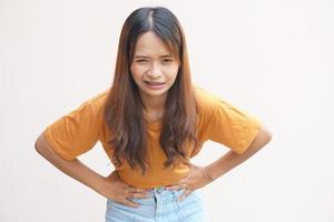 asiatico donna avendo mal di stomaco a partire dal mestruazione foto