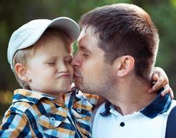 padre e il suo bambino figlio avendo divertimento nel il parco all'aperto foto