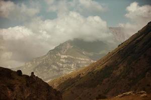 alto nero roccia nel Basso nuvole. surreale cupo montagne. foto