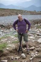 un' uomo è le riprese un' cavo auto nel il montagne con un' video telecamera. un' turista scrive un' Youtube blog mentre in viaggio. foto