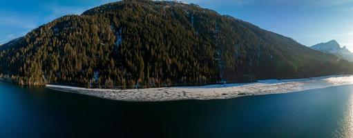 aereo Visualizza di il neve roccioso scogliere con foresta di il lago. drammatico e pittoresco scena. foto