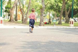 un' ragazzo in esecuzione su il strada nel il parco foto