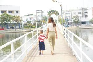 madre prende bambino per un' camminare nel il parco vacanza foto