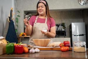 ritratto di obeso donna cucinando Pizza nel il cucina, crudo Pizza nel il mani di un' casalinga. fatti in casa Pizza cucinando nel il cucina a casa. apprendimento Come per rendere delizioso Pizza cena pranzo foto